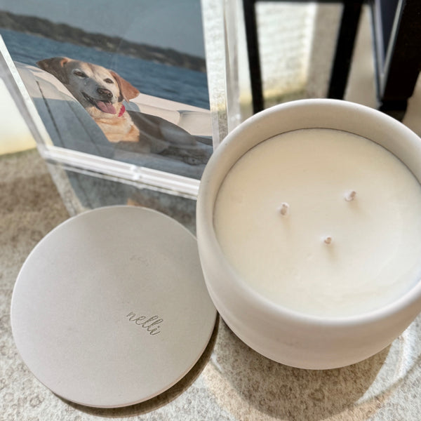 Custom concrete candle in charcoal gray. An example of the engraved lid shows the dog naemorial came, "Magge" in an elegant script font. Each concrete candle is 5.5" in diameter and 3.5" deep with three wicks to burn evenly. Choose a fragrance sucj as Rolling in the grass, Big Stick and also Unscented.  Makes the perfect custom pet memorial gift.