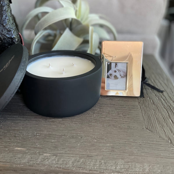 Custom concrete memorial candle in charcoal gray. An example of the engraved lid shows the dog name, "Magge" in an elegant script font. Each concrete candle is 5.5" in diameter and 3.5" deep with three wicks to burn evenly. Choose a fragrance sucj as Rolling in the grass, Big Stick and also Unscented.  Makes the perfect custom pet memorial gift.